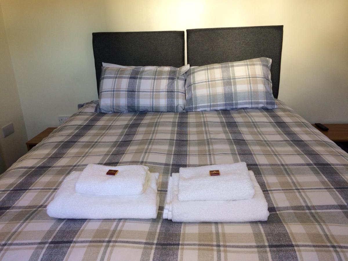 Corran Bunkhouse Hotel Bagian luar foto A bed with towels